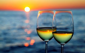 wine in glasses with ocean and sunset