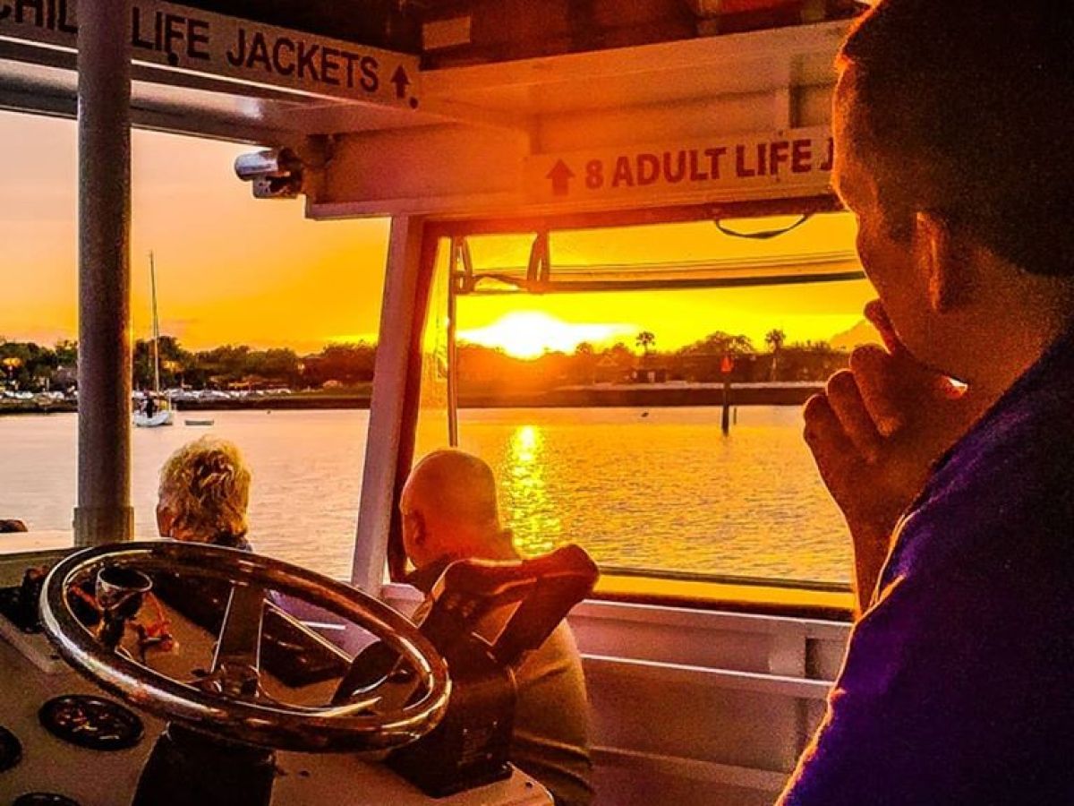 orange sunset from boat with steering wheel