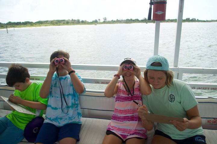 a couple of people that are sitting in front of a body of water
