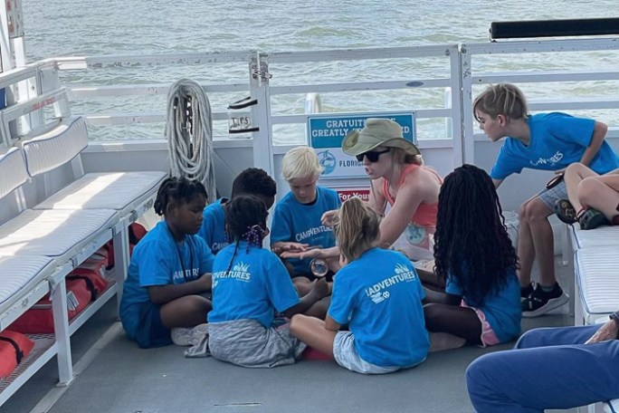 a group of people sitting at a dock