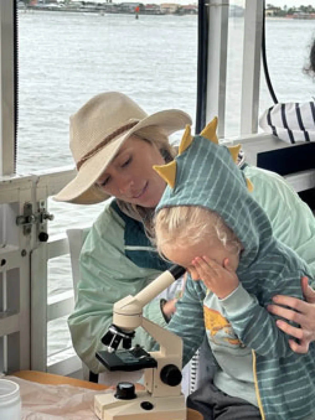 a group of people sitting at a table in front of water