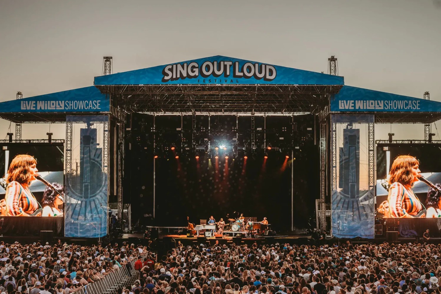 a group of people watching a band on stage in front of a crowd