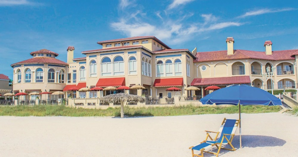 a group of lawn chairs sitting on top of a sandy beach