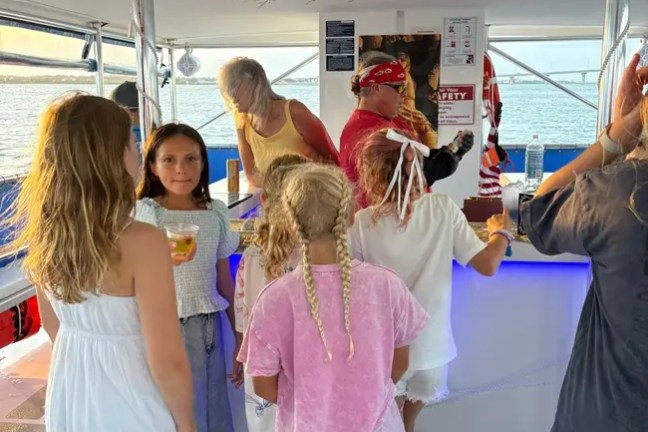 Children gathered around a boat bar with colorful lights.