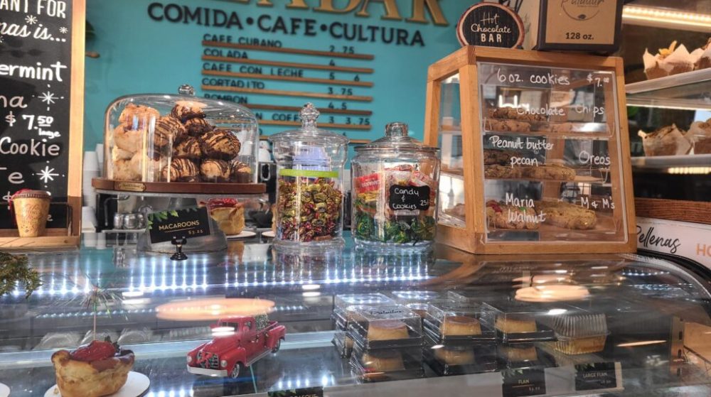 Bakery counter with pastries and cookies in glass jars and display case.
