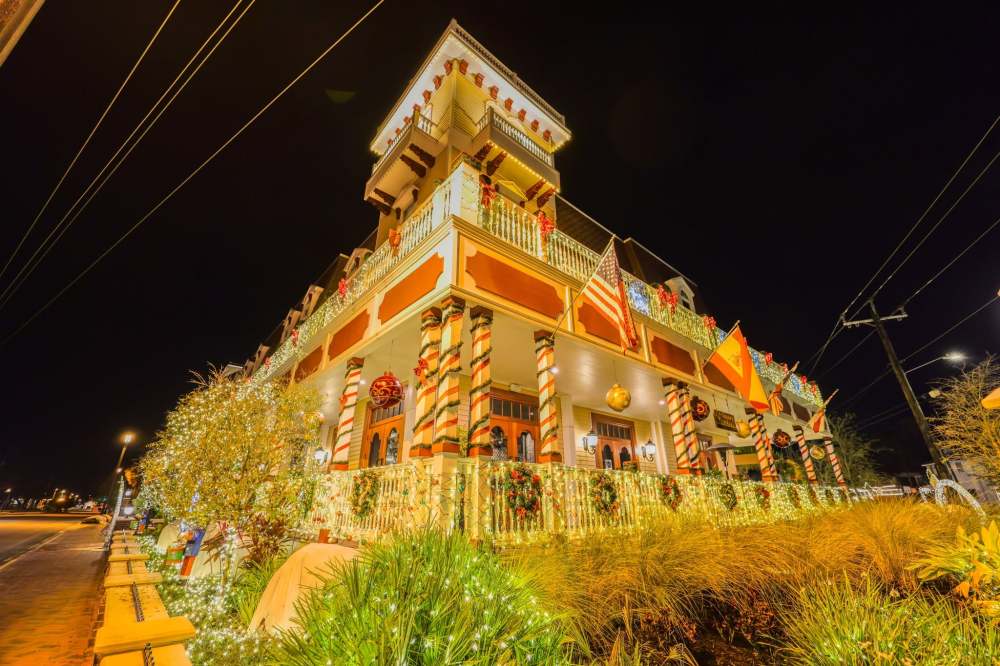 Festive house decorated with colorful lights and ornaments at night.